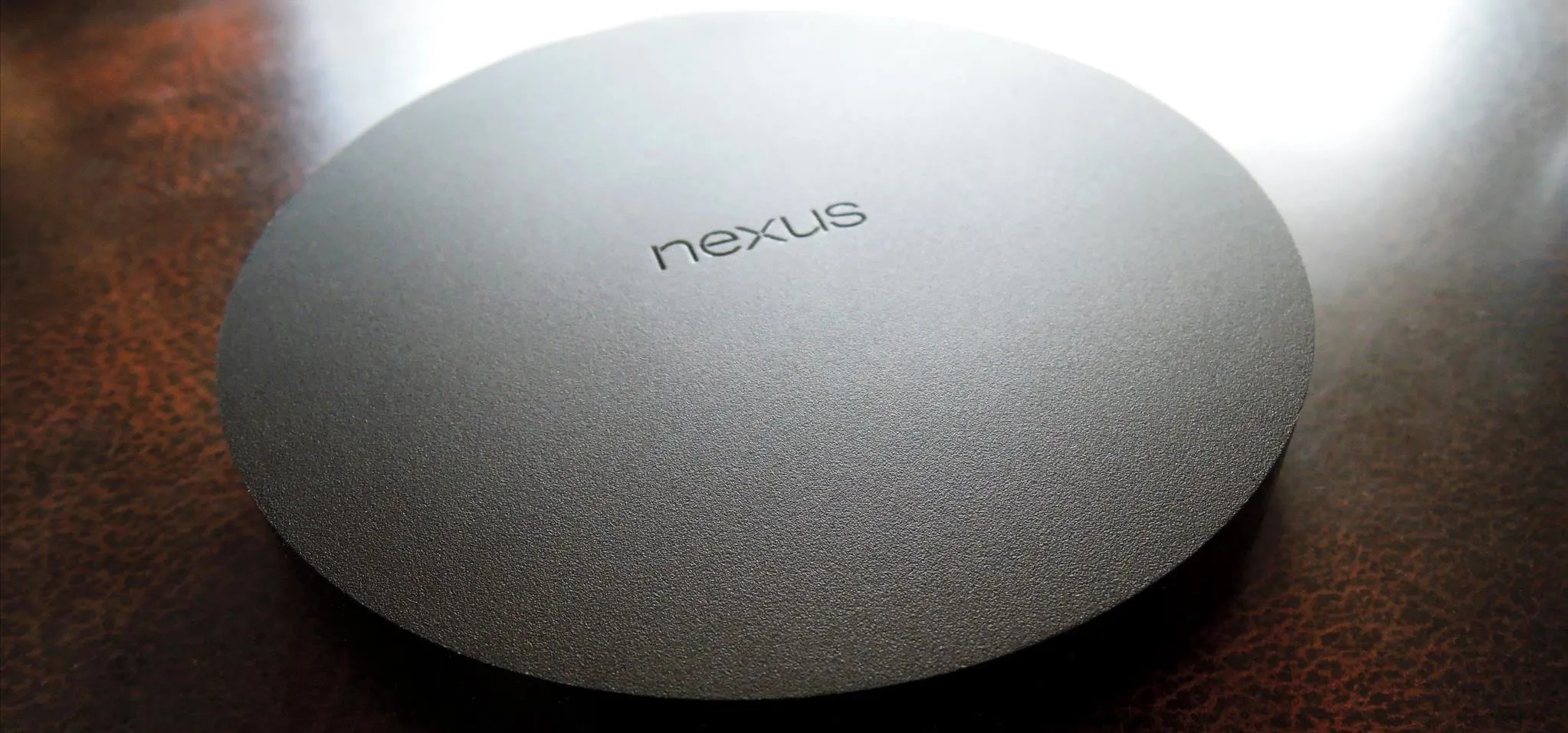 Nexus wireless charging pad on a wooden surface.